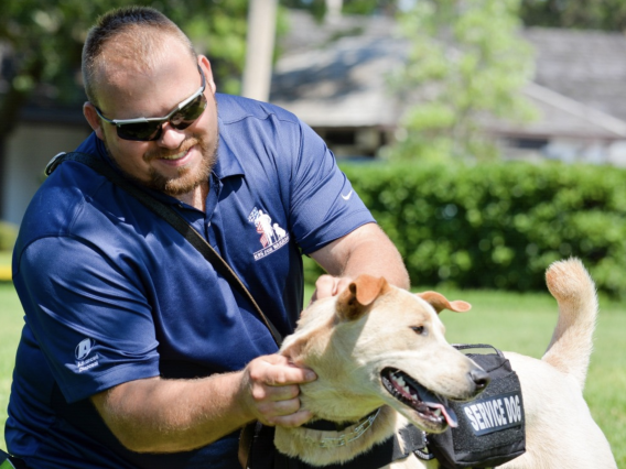 serviceman petting golden service dog