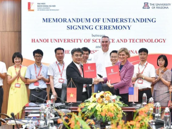 Associate dean of research Mark Van Dyke (center, back) and vice president for semiconductor strategy Liesl Folks (center right, shaking hands