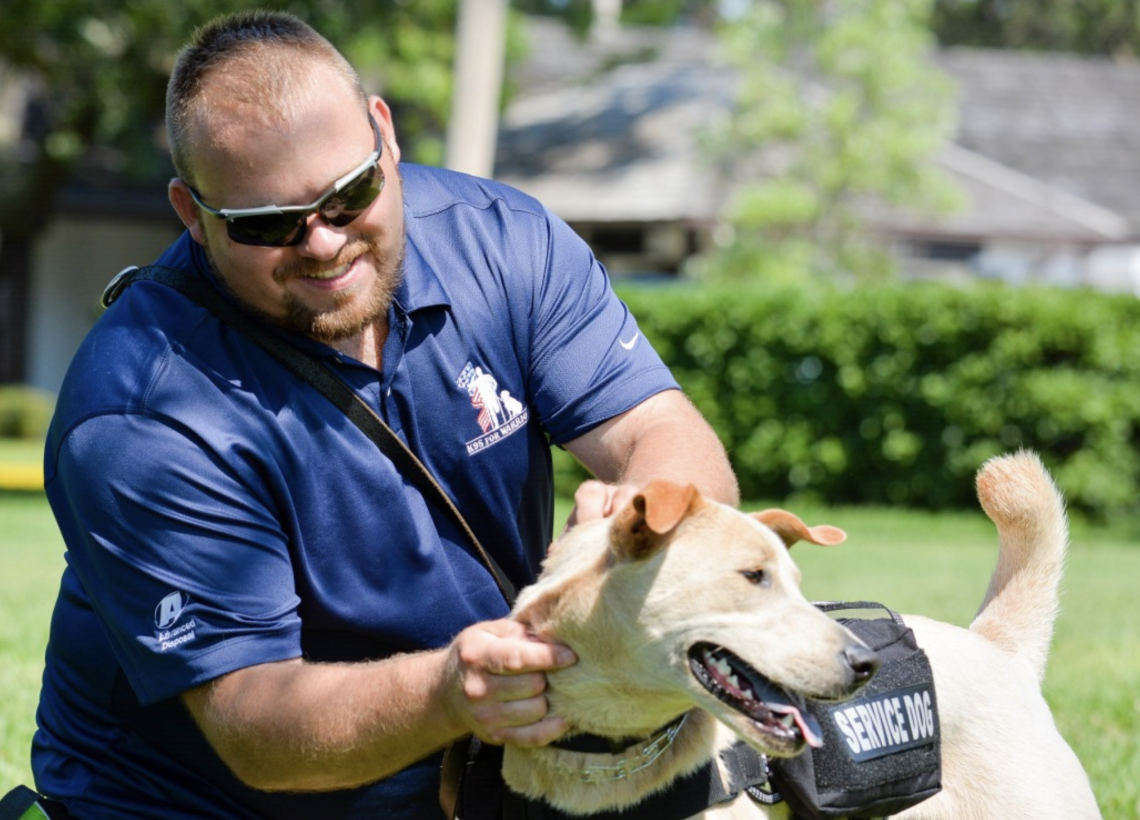 serviceman petting golden service dog
