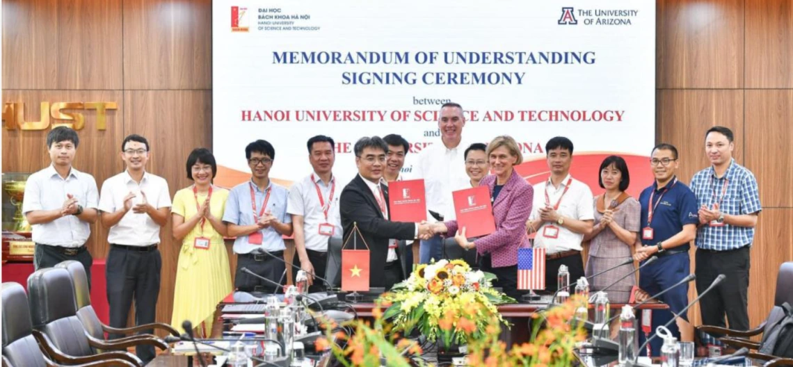 Associate dean of research Mark Van Dyke (center, back) and vice president for semiconductor strategy Liesl Folks (center right, shaking hands