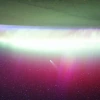 A bright, neon-like aurora radiates above Earth, seemingly absorbing Comet Lemmon (C/2025 A6) as it soars past the planet at a distance of about 57.2 million miles (92.1 million kilometers) in October 2025.